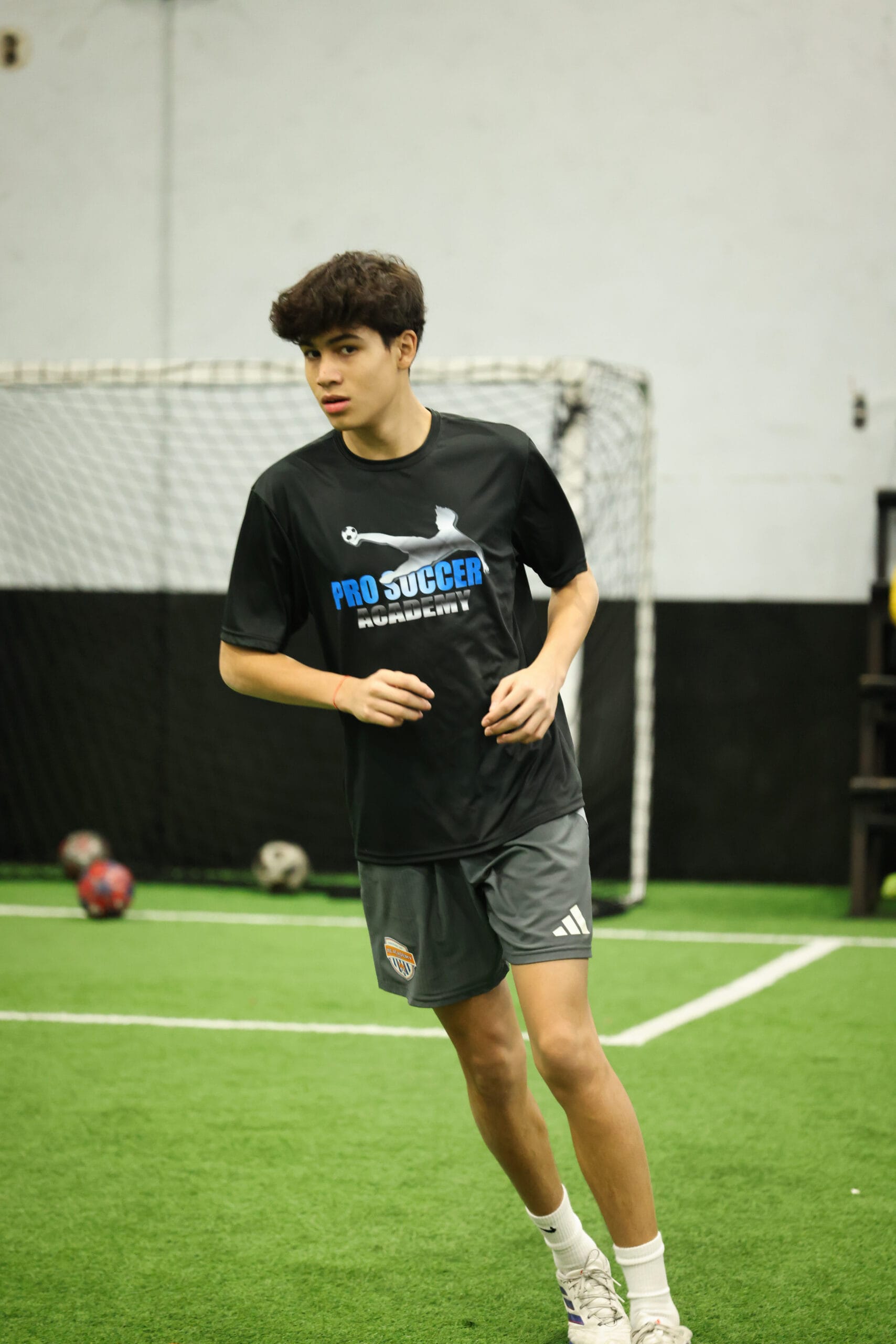 5K2A0310 Youth soccer player training indoors at Pro Soccer Academy focusing on movement, agility, and ball control on turf field