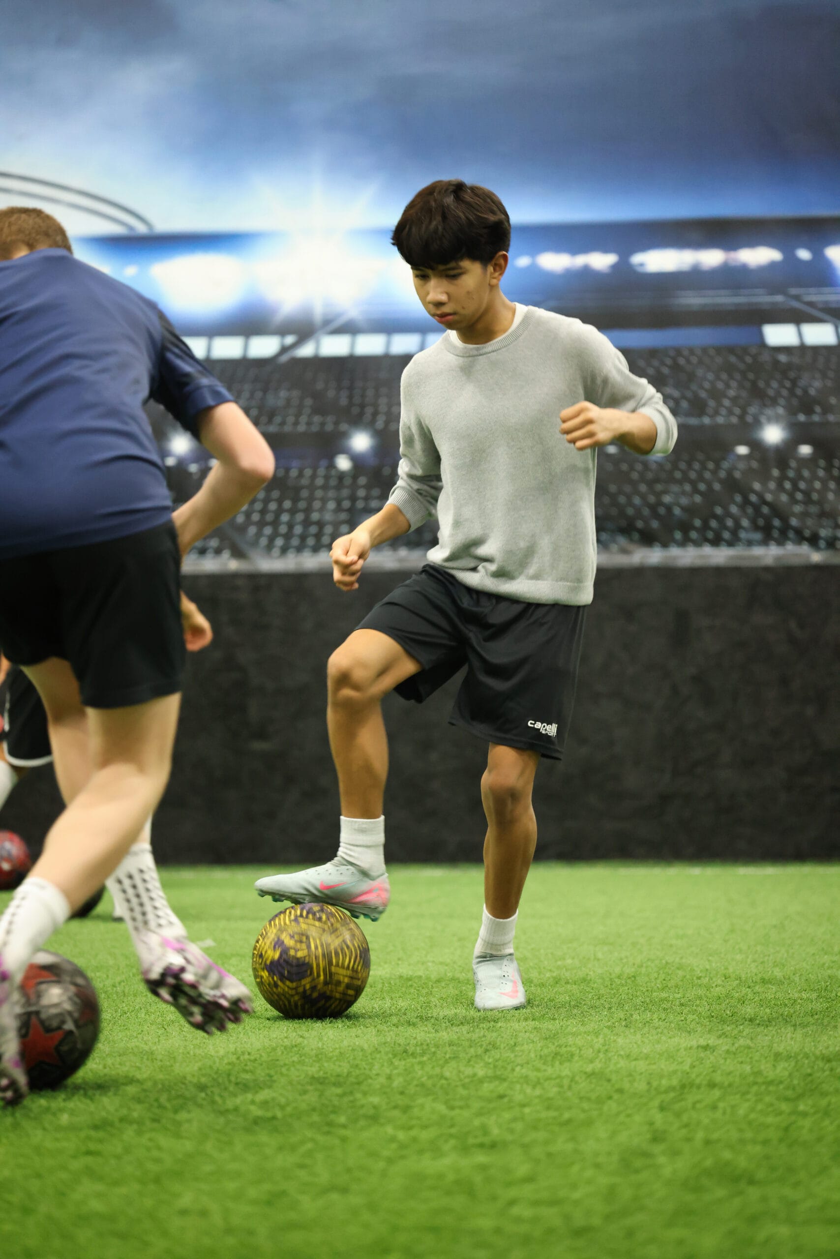 5K2A0414 Youth soccer player controlling the ball under pressure during indoor technical training at Pro Soccer Academy