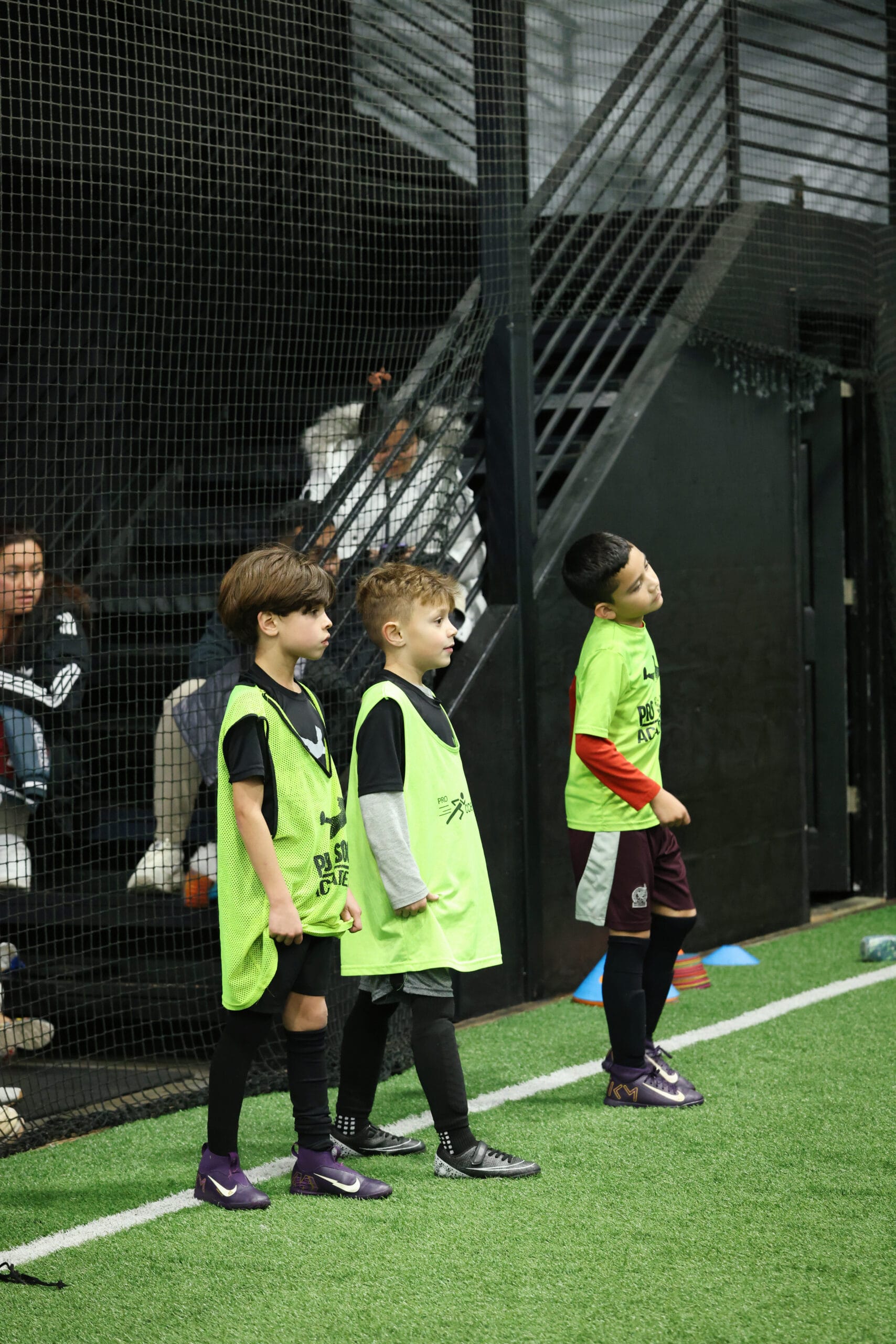 5K2A8678 Youth soccer players standing in line during an indoor soccer training session in New Jersey, listening and preparing for a drill on turf field