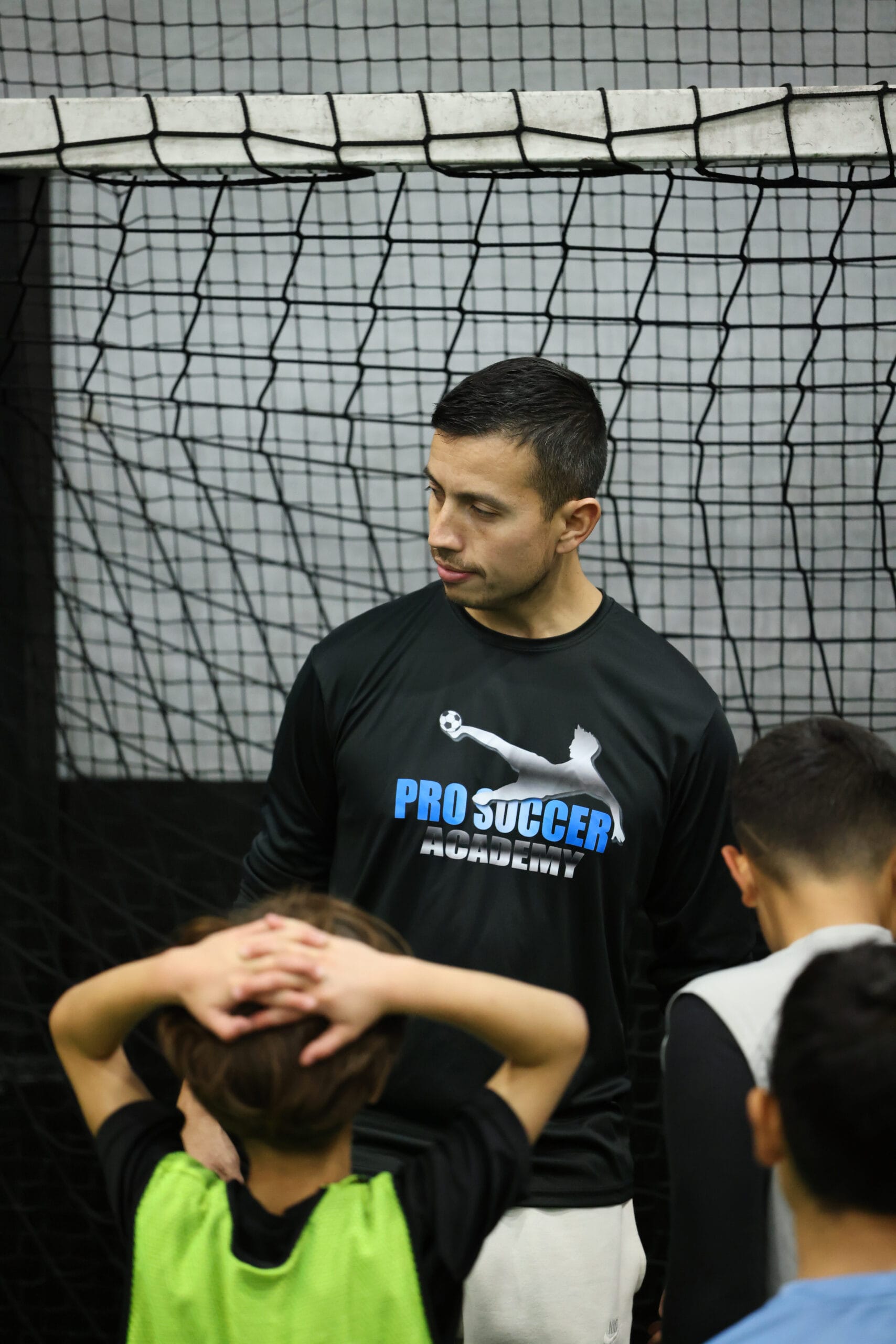 5K2A8706 Coach Dan guiding youth players through instruction focused on soccer development