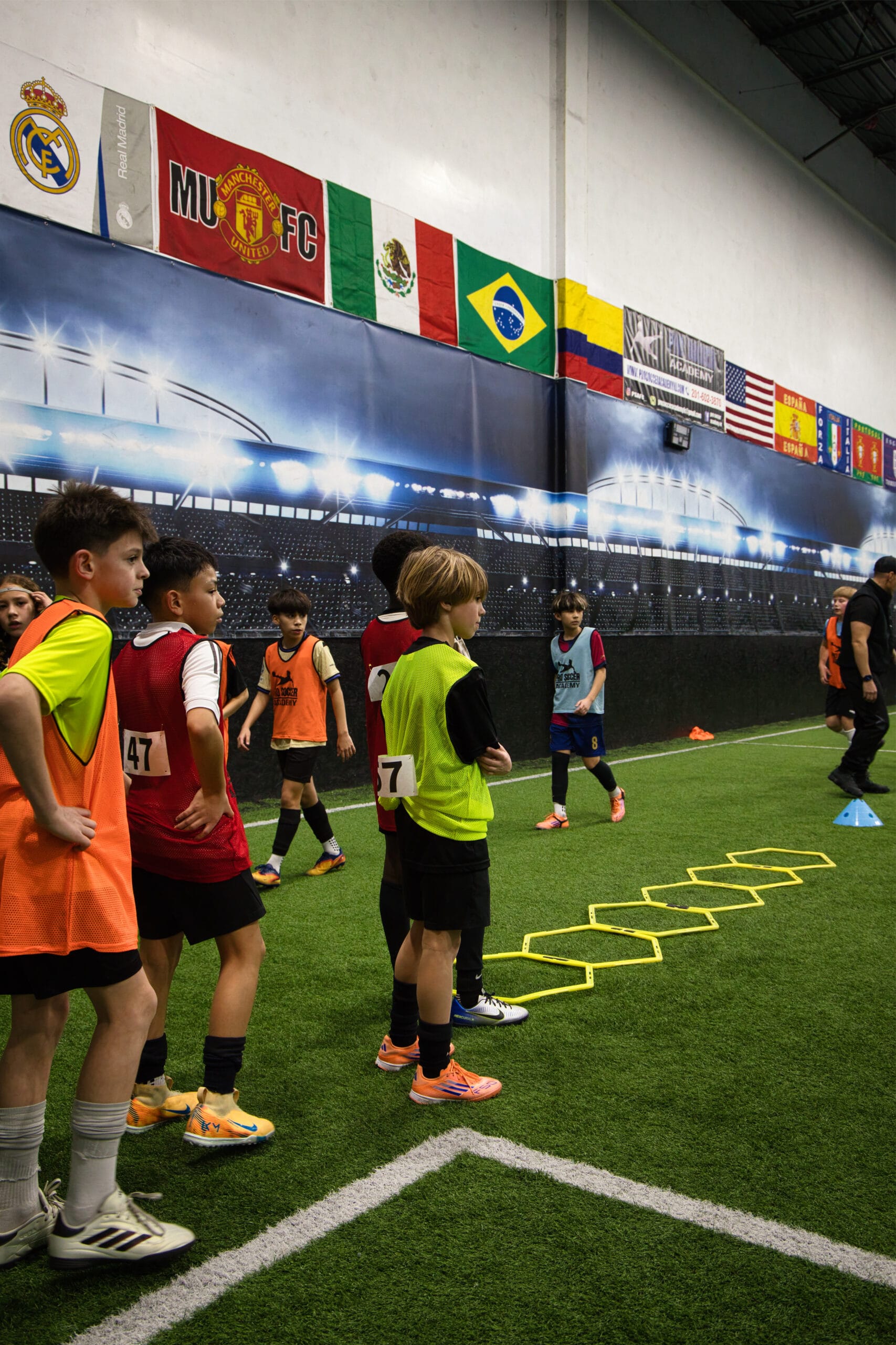 4Q8A0103 Youth soccer players completing agility ladder drill at Pro Soccer Academy indoor facility