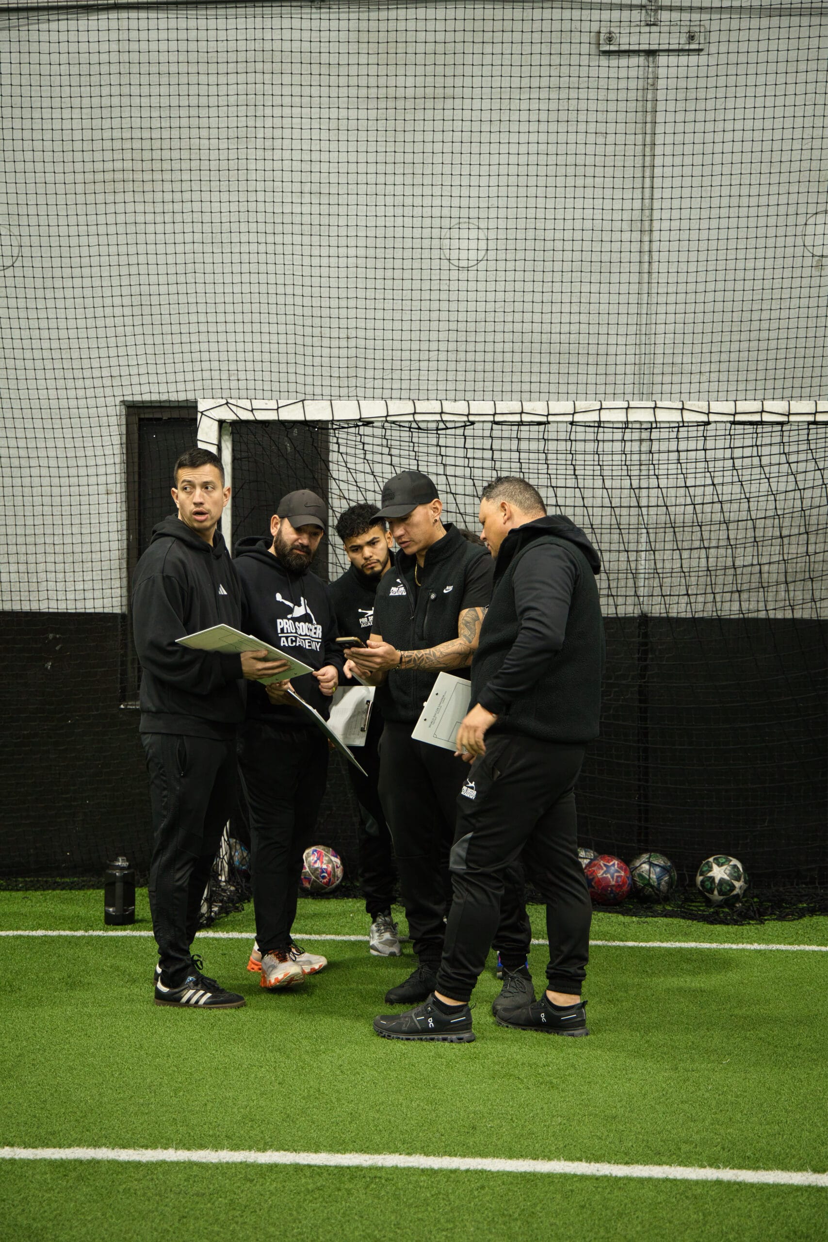 4Q8A0123 Pro Soccer Academy coaching staff reviewing player evaluations during indoor tryouts