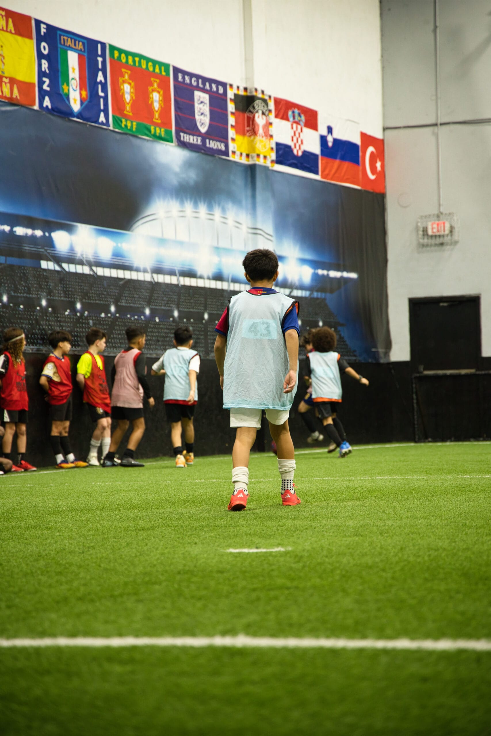 4Q8A0176 Youth soccer players lined up along wall during indoor scrimmage at Pro Soccer Academy