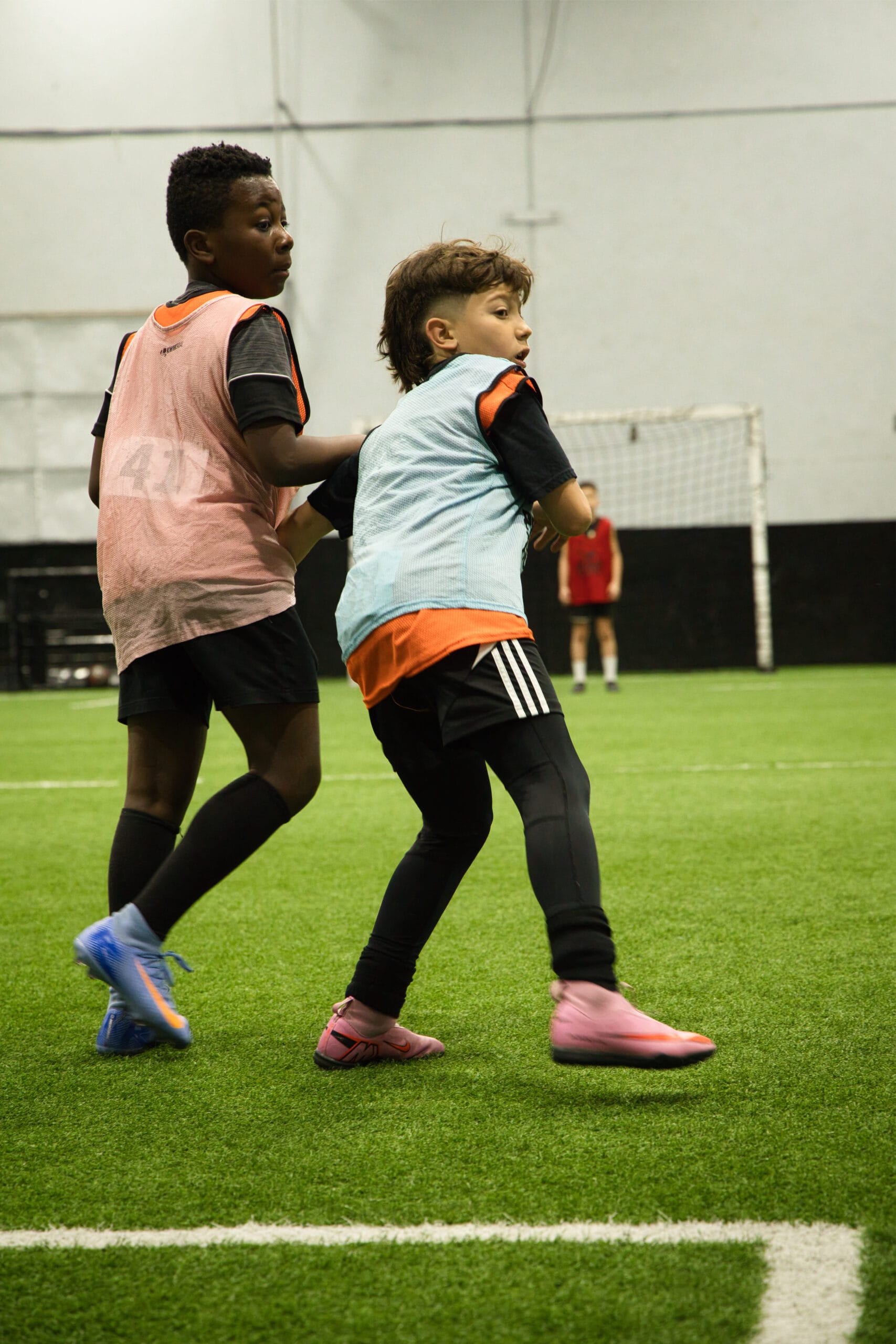 4Q8A0187 Youth soccer players battling for possession near goal during Pro Soccer Academy indoor game