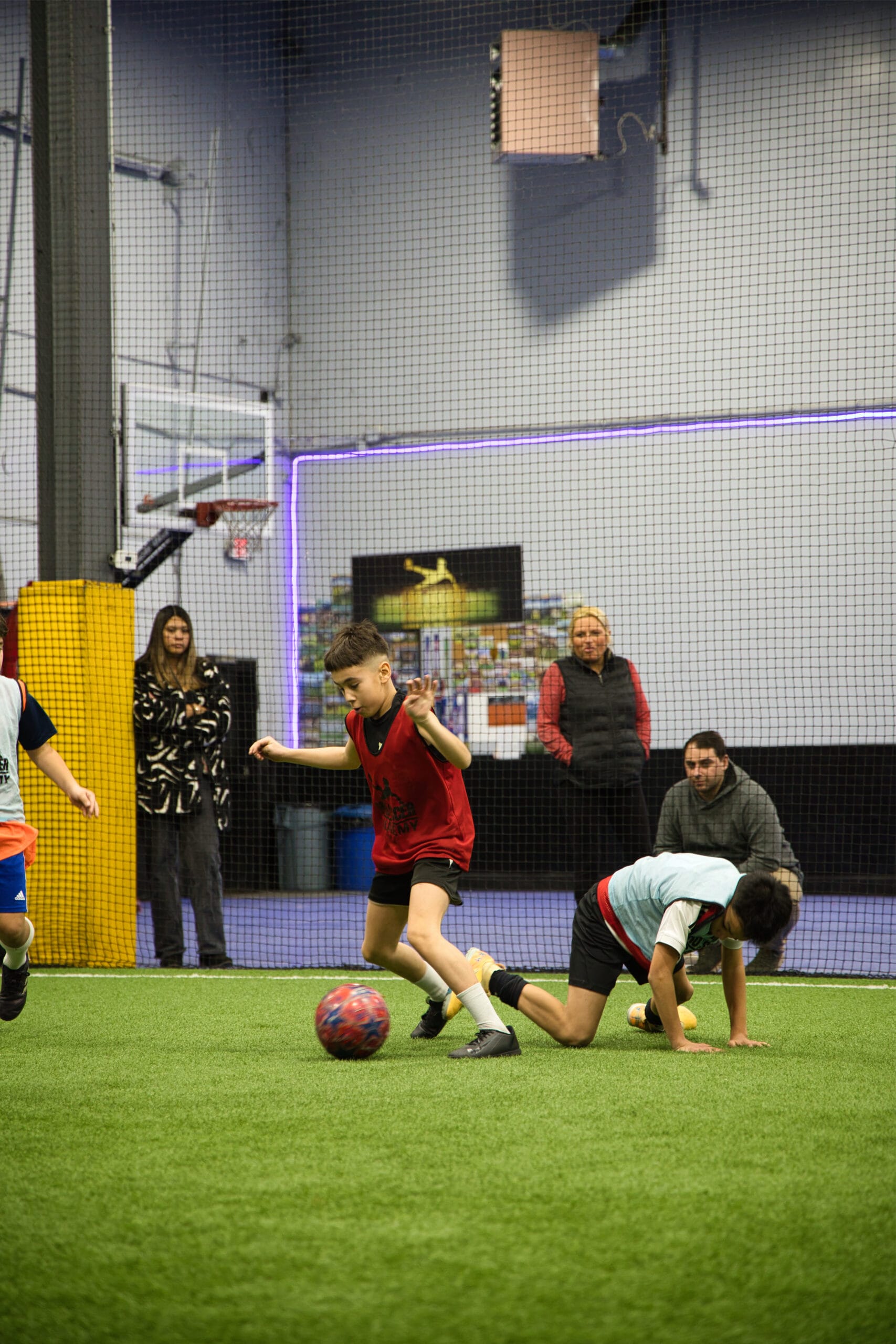 4Q8A0214 Youth soccer player in red bib focused and ready during Pro Soccer Academy indoor session