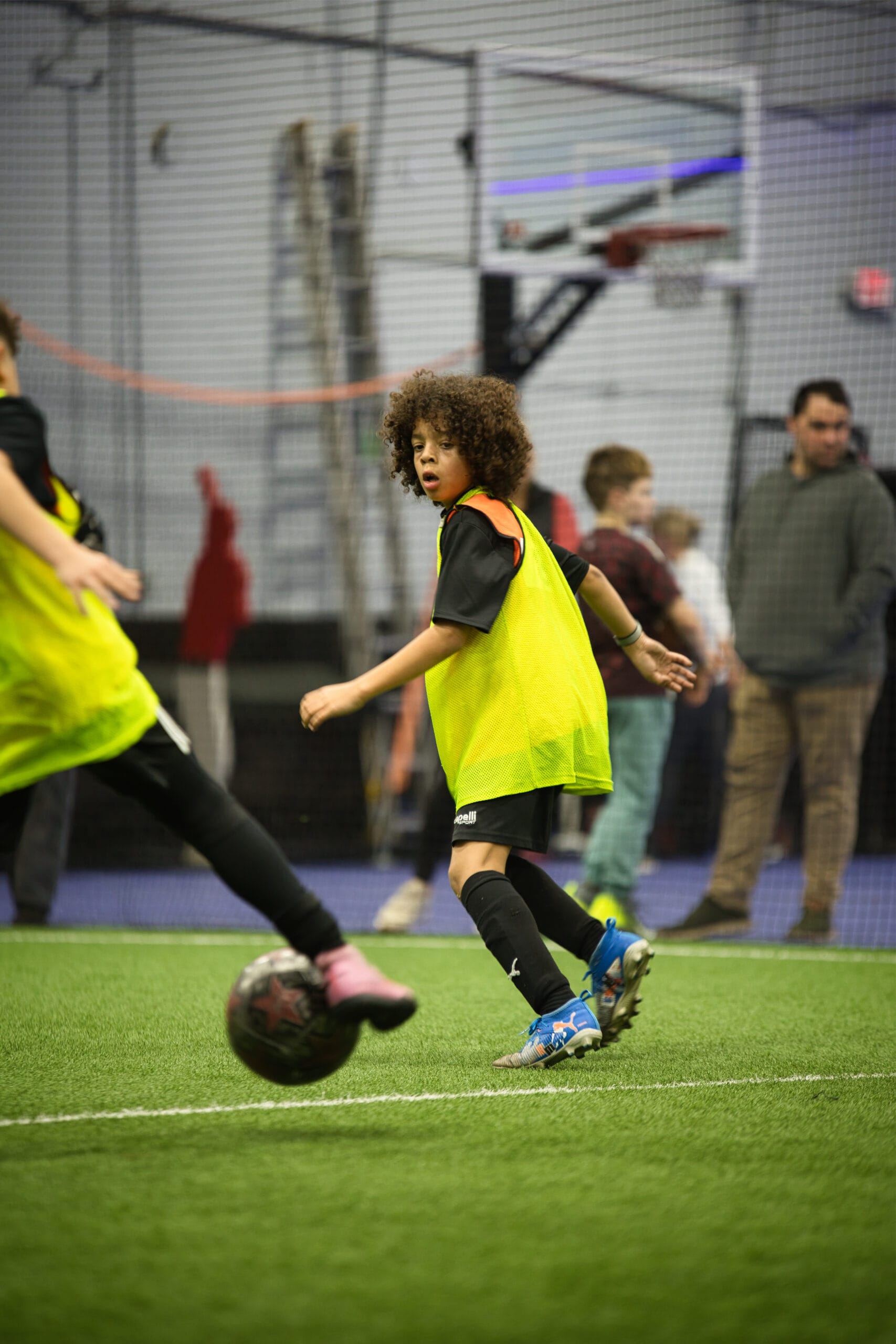 4Q8A0316 Young soccer player tracking the ball while teammate passes during indoor Pro Soccer Academy match play.