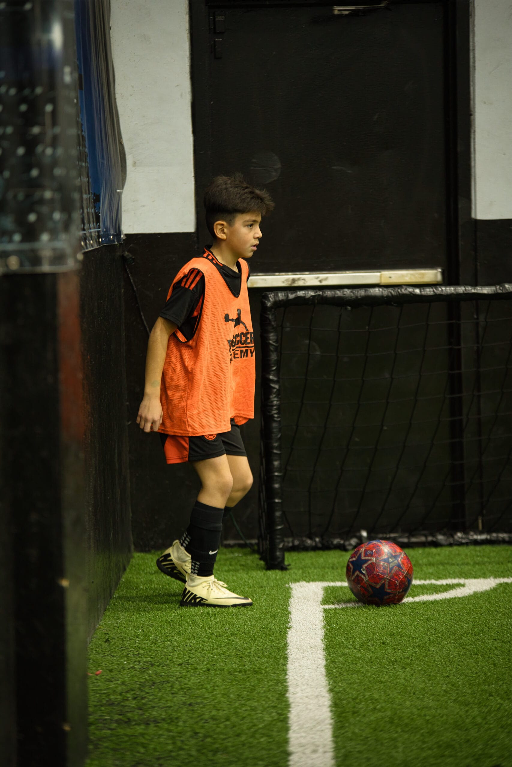 4Q8A0349 Youth player preparing for corner kick inside indoor Pro Soccer Academy facility.