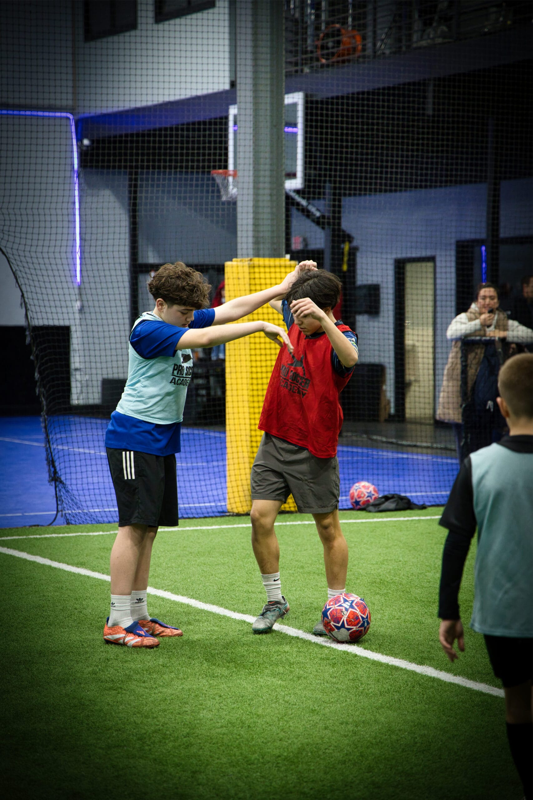 4Q8A0305 Two youth soccer players on opposite teams pushing and shielding the ball during a competitive match at Pro Soccer Academy.