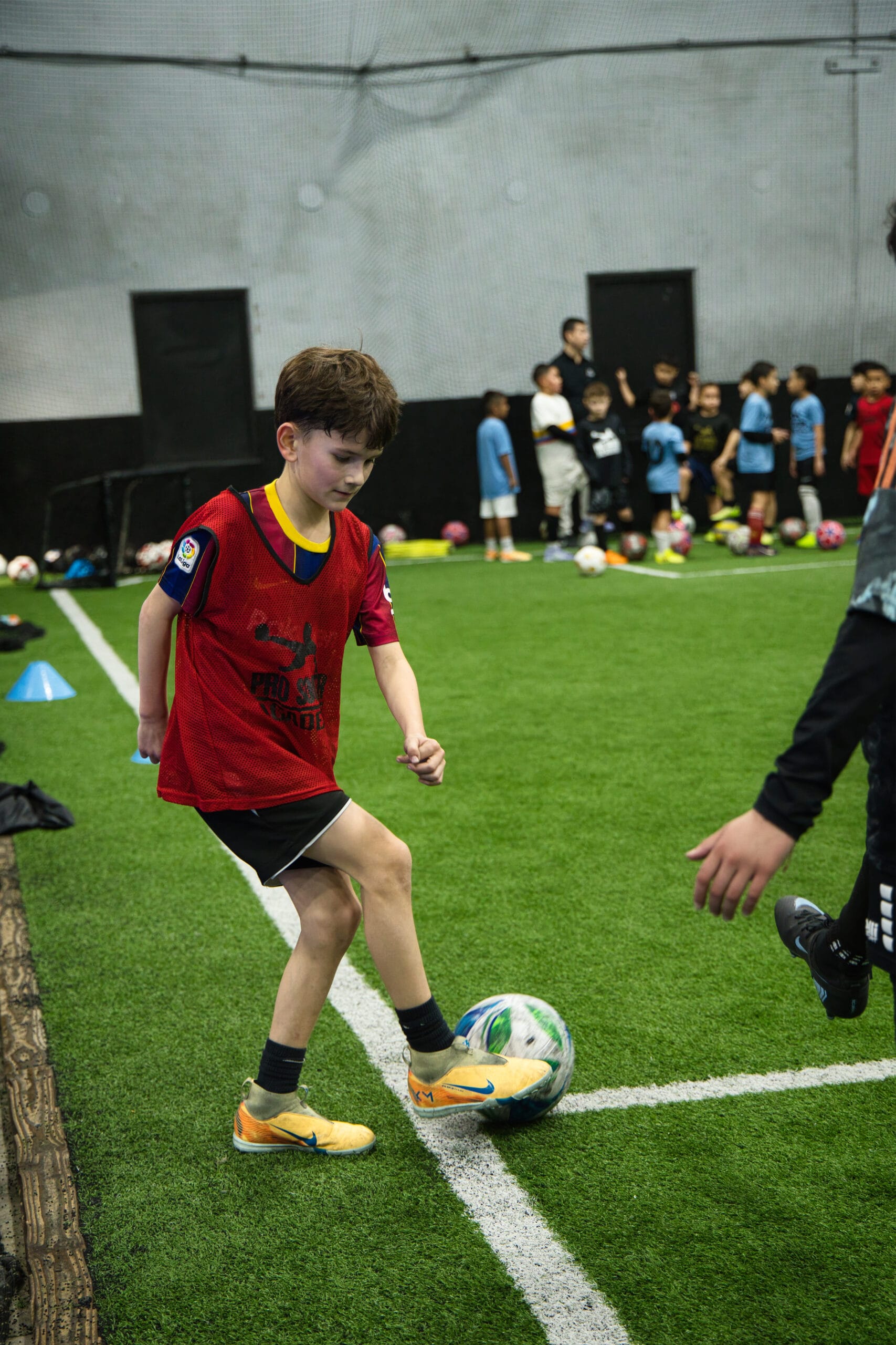 4Q8A0325 Youth soccer player controlling the ball near the sideline during Pro Soccer Academy training.