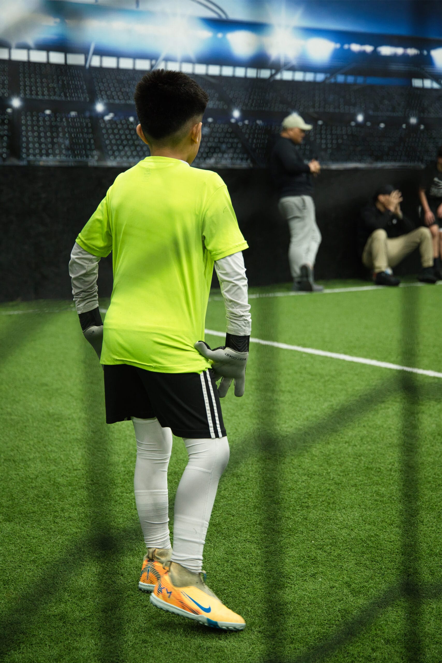 4Q8A0337 Youth goalkeeper preparing for action during an indoor soccer training session at Pro Soccer Academy.