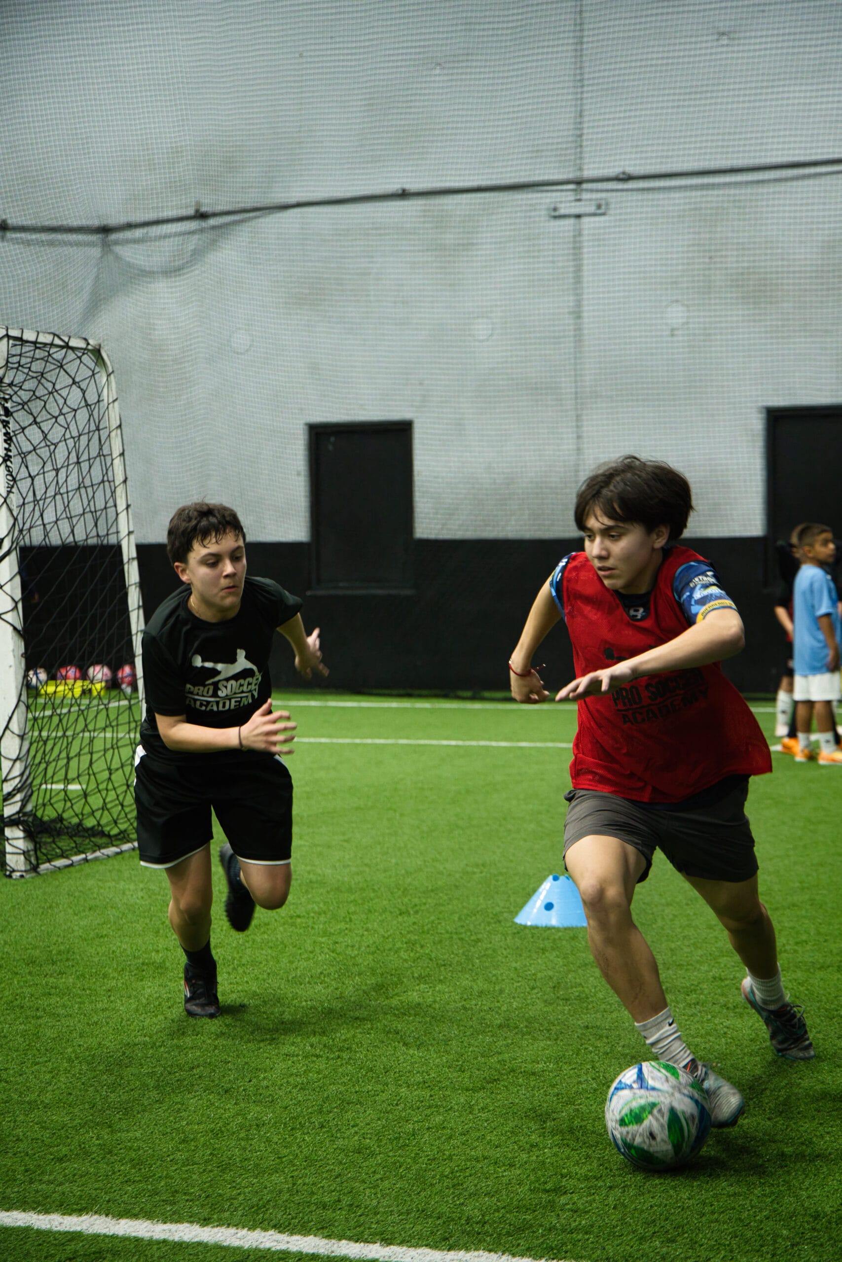 4Q8A0338 Young soccer player dribbling forward during a Pro Soccer Academy training drill.