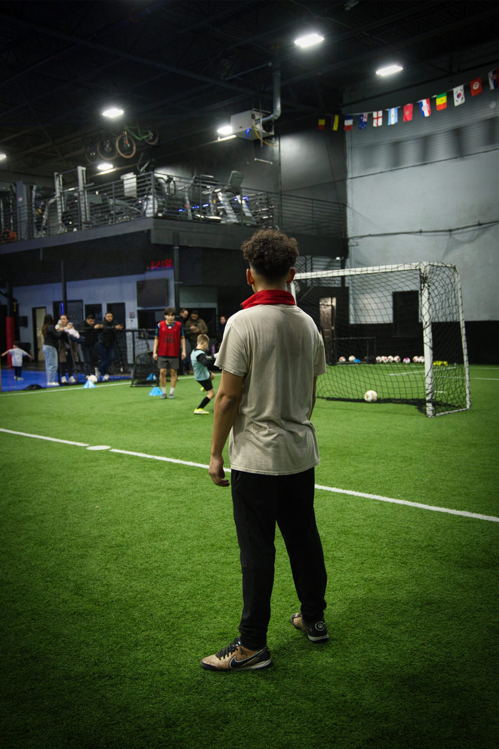 4Q8A0343 Soccer player observing youth players during indoor training at Pro Soccer Academy.
