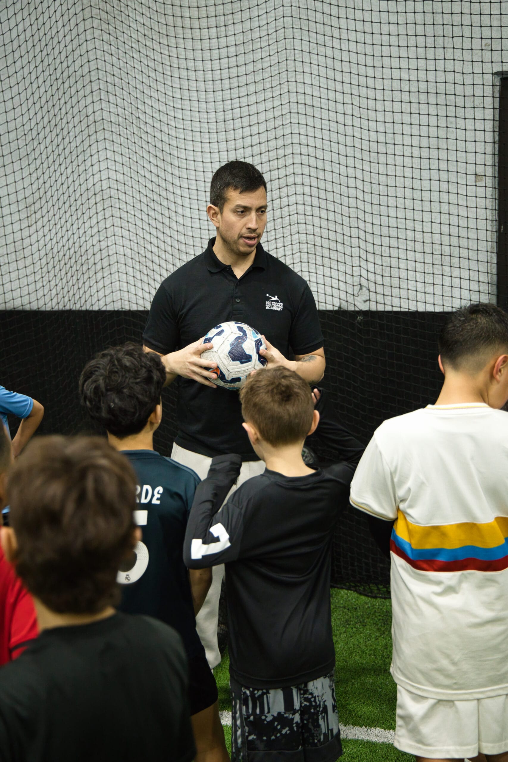 4Q8A0417 Soccer coach explaining a drill to youth players during training at Pro Soccer Academy.