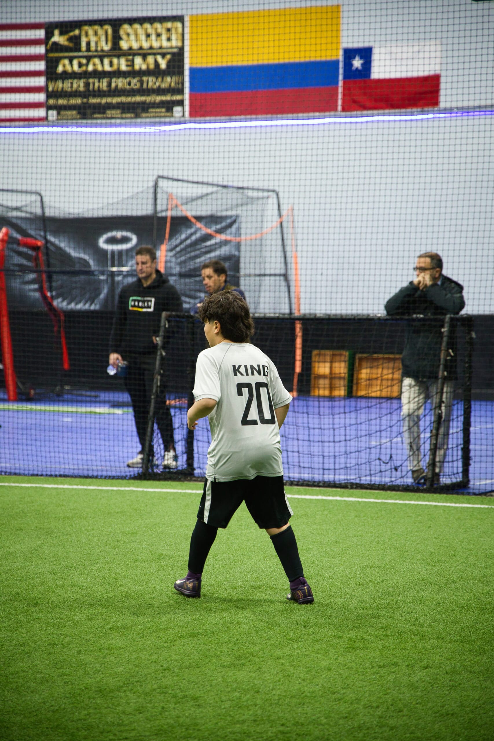 Youth soccer player wearing number 20 preparing for play during indoor training session at Pro Soccer Academy