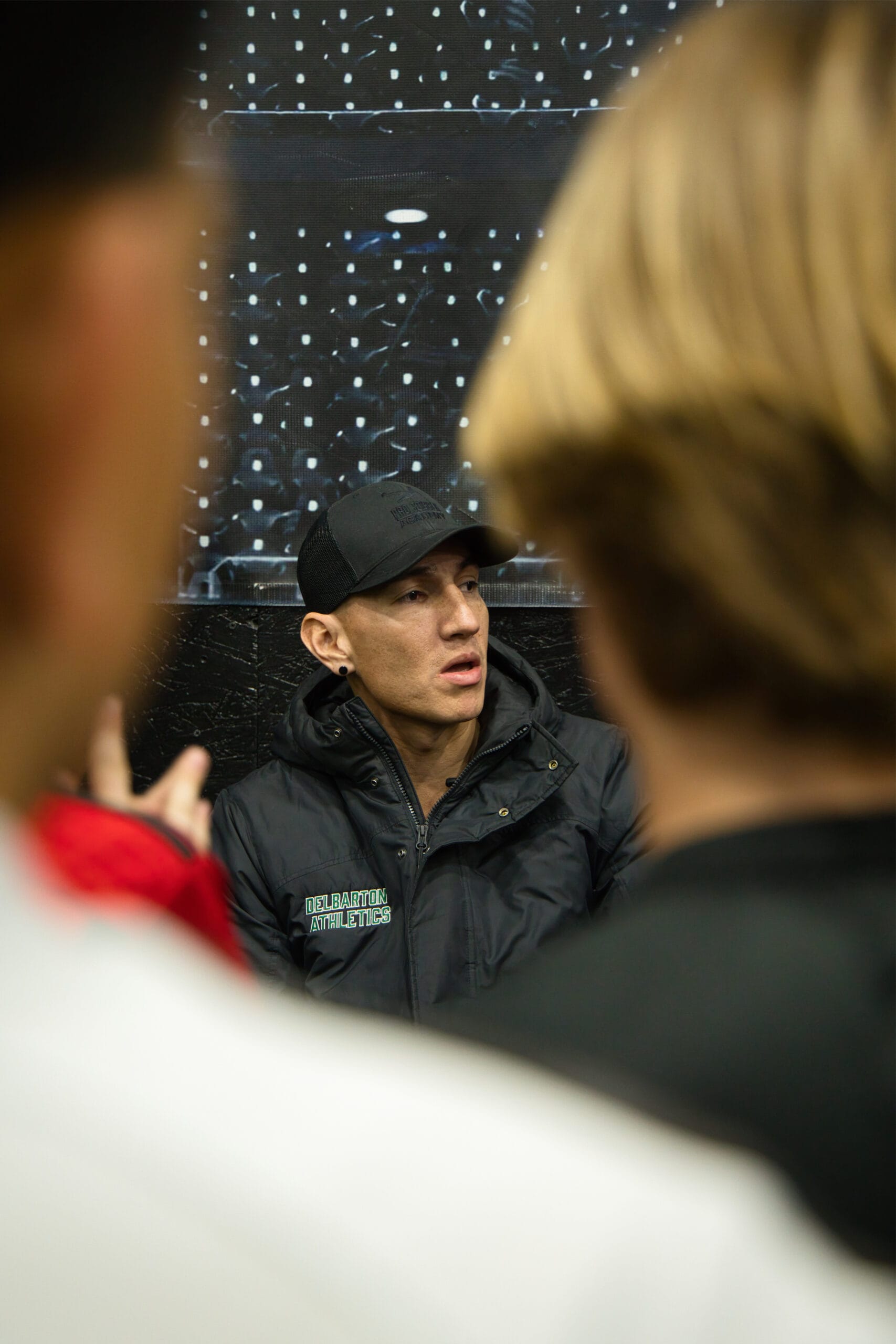 Soccer coach speaking to youth players during indoor training session at Pro Soccer Academy