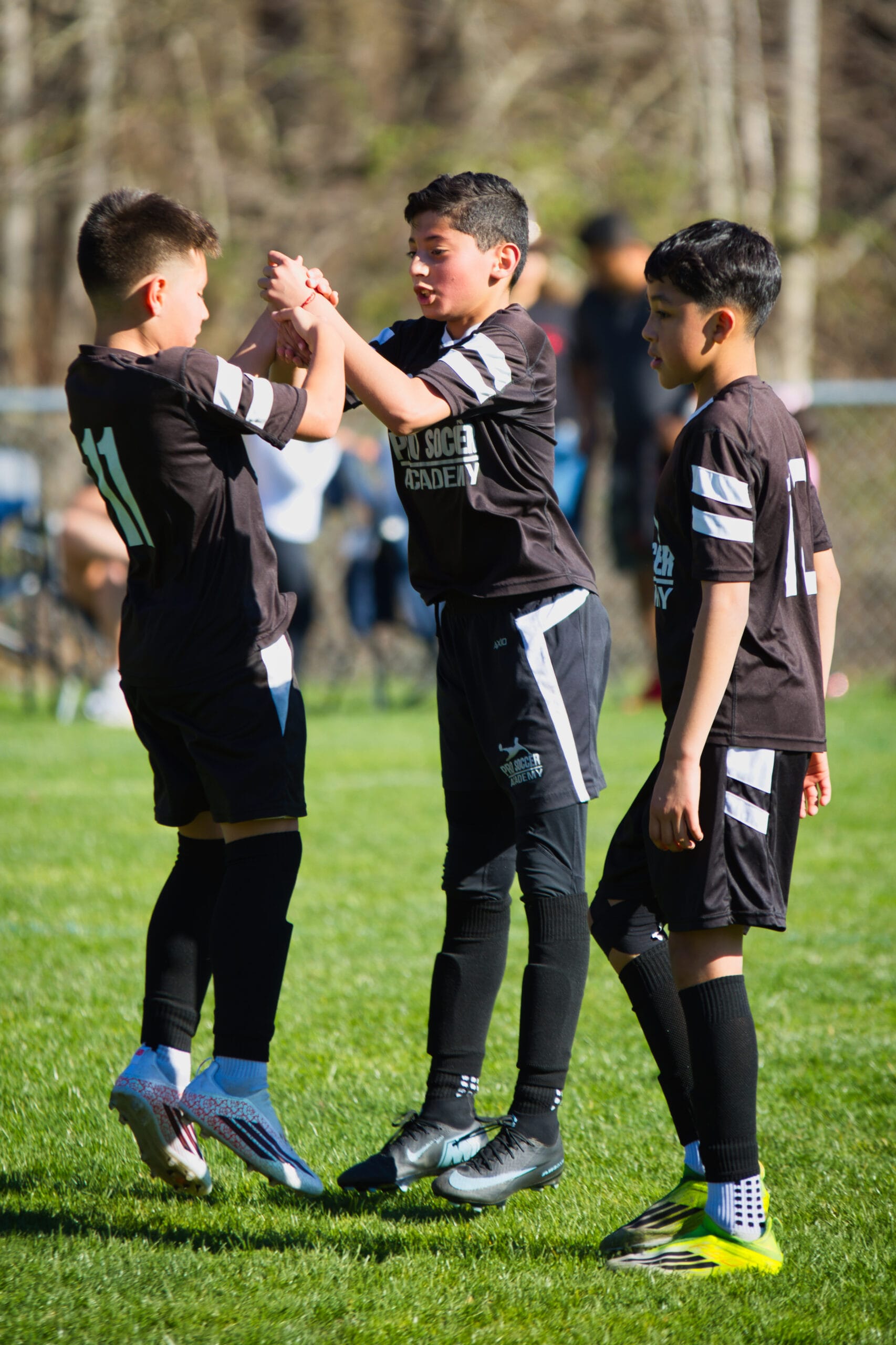 Youth soccer players celebrating together after a play at Pro Soccer Academy