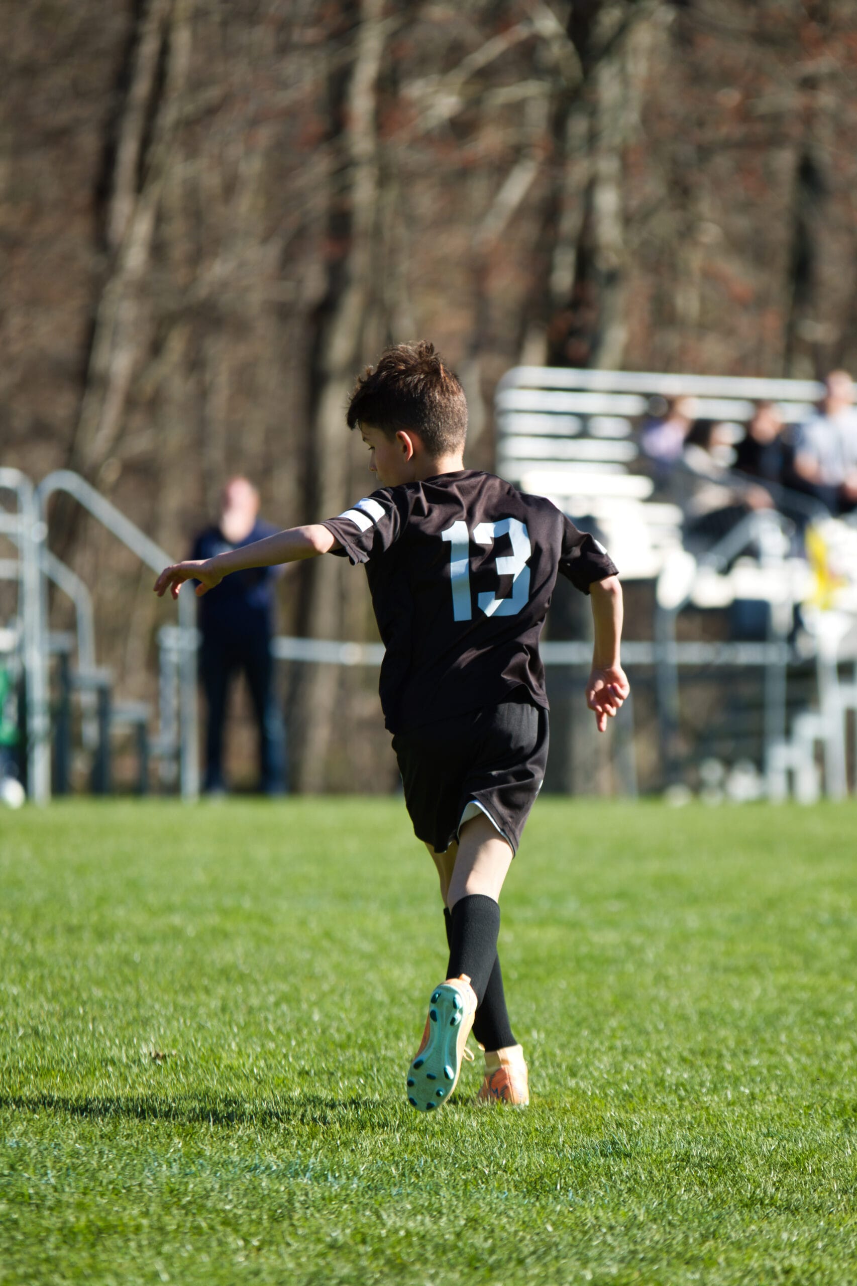 Young soccer player preparing for drill near sideline during indoor youth training session at Pro Soccer Academy