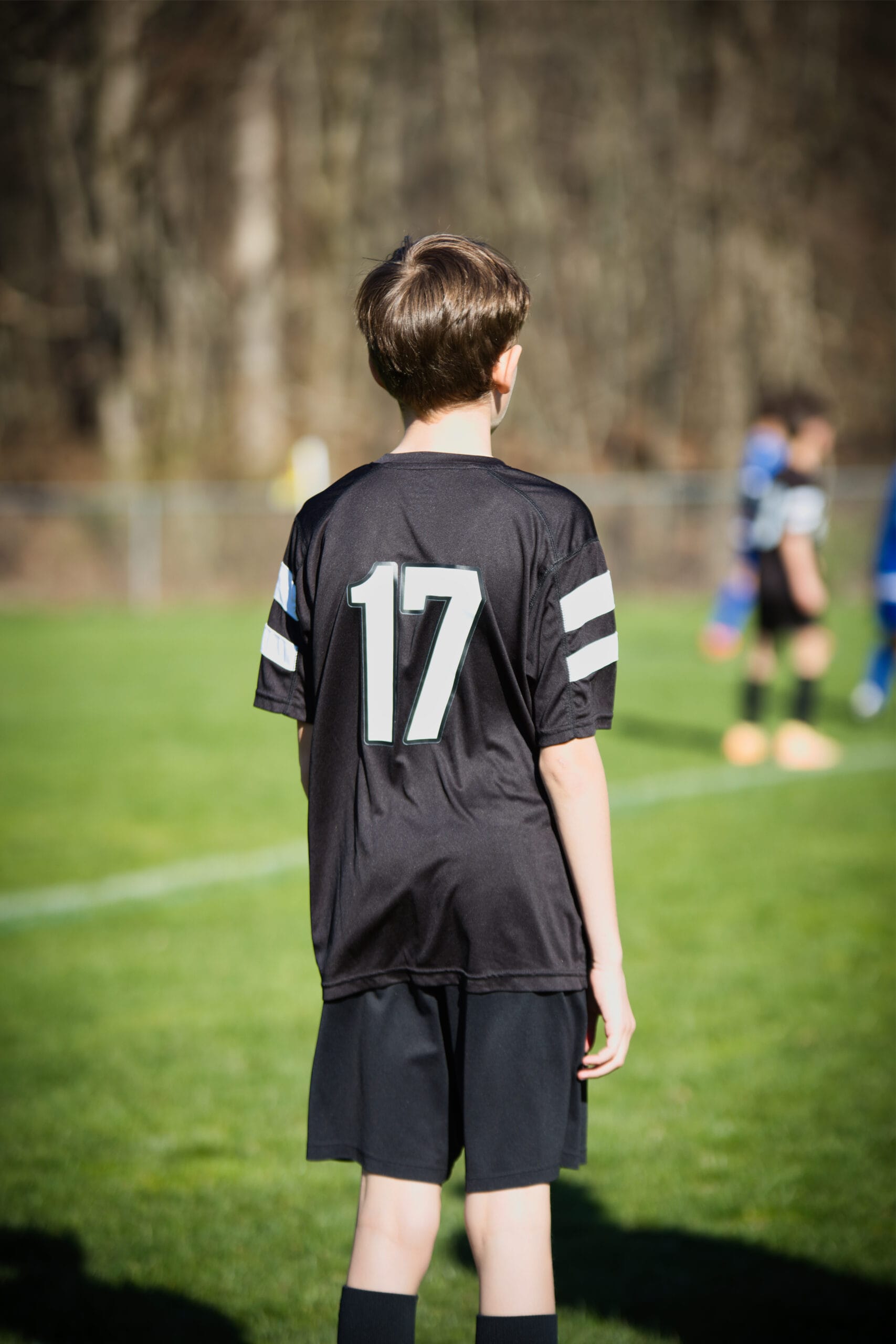 Soccer coach standing on indoor field at Pro Soccer Academy overseeing youth training session